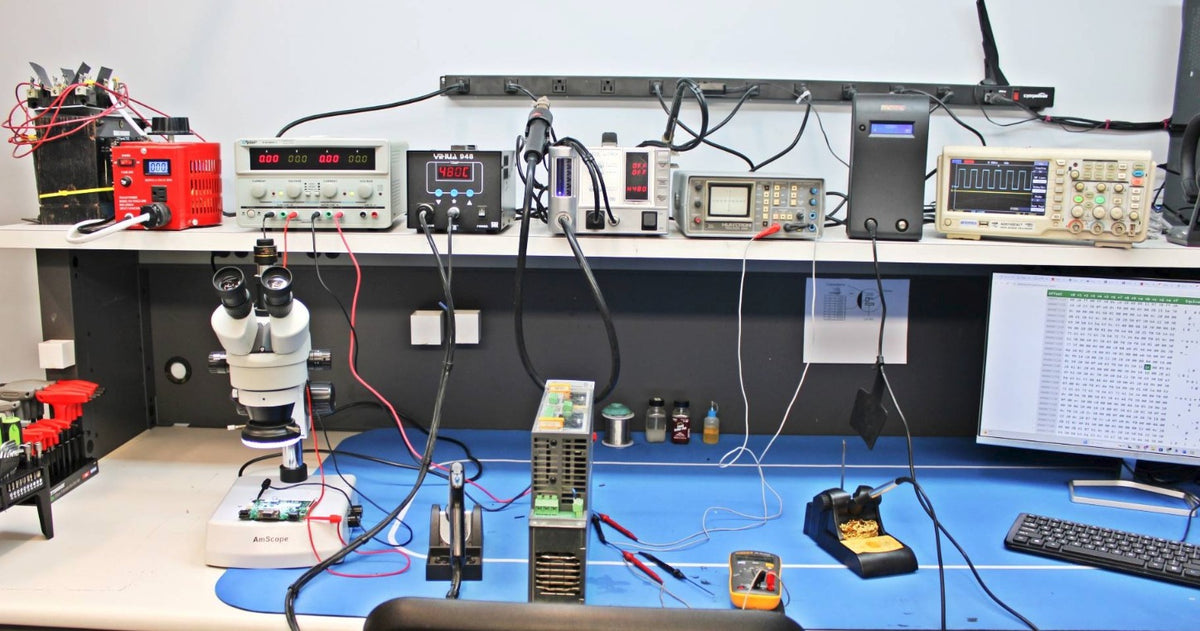 Flexa Systems component-level repair bench: stereo microscope, bench power supply, hot-air rework station, oscilloscope and soldering station used to diagnose industrial drives